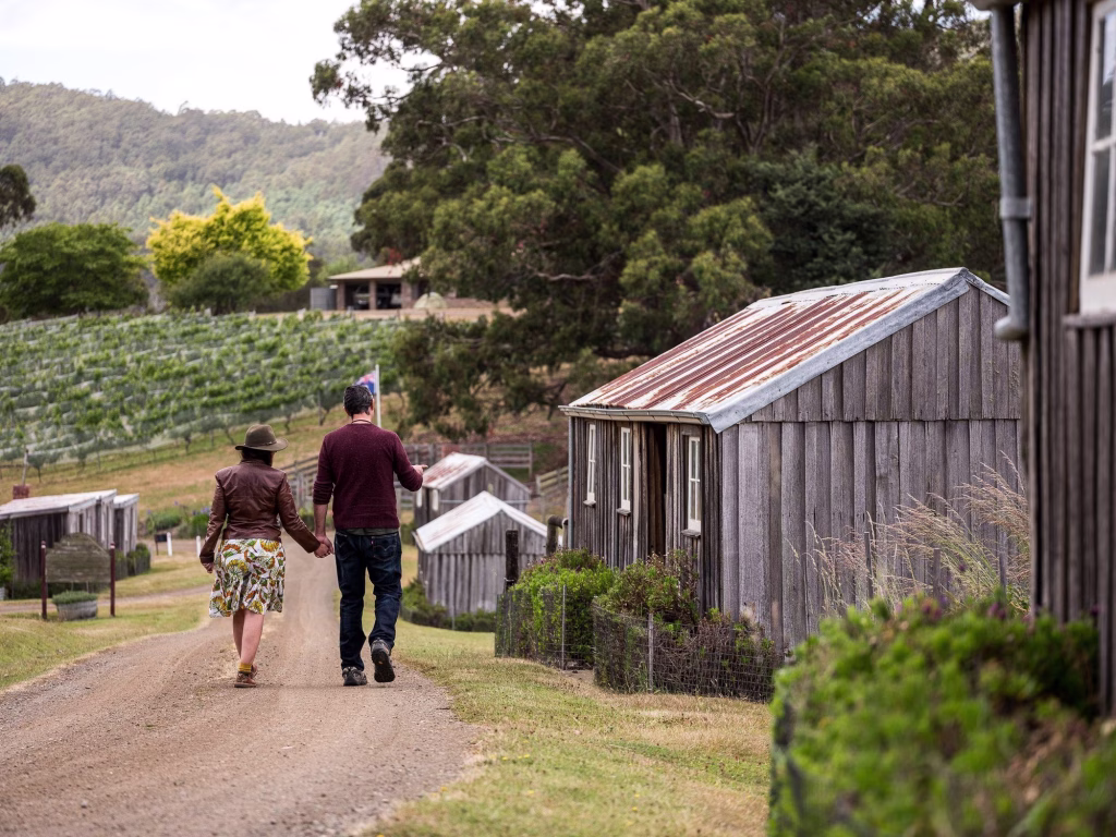 A man and woman hold hands walking by the Pickers Hits at Hartzview Vineyard in Tasmania. Photo: Andrew Wilson